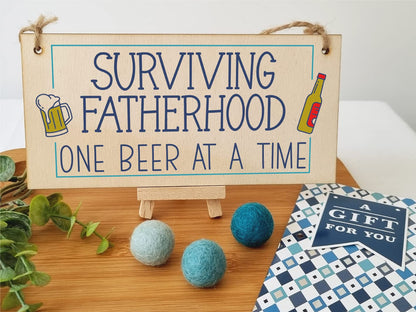 The Plum Penguin Handmade Wooden Hanging Wall Plaque Surviving Fatherhood One Beer at a Time Novelty Sign Man Cave
